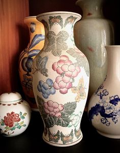 several vases are lined up on a shelf