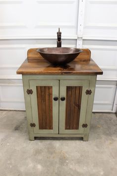 a bathroom sink sitting on top of a wooden counter next to a white garage door