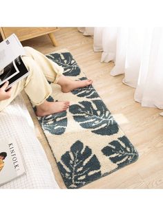 a person sitting on the floor with a book in their hand while reading a book