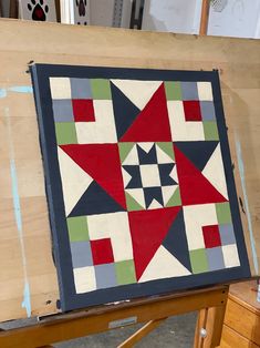 a quilt is being displayed on a easel