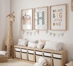 a child's room decorated in white and neutrals with giraffe art on the wall