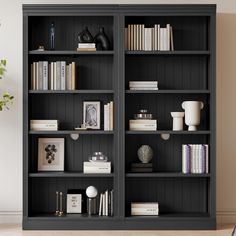 a black bookcase filled with lots of books next to a vase and potted plant