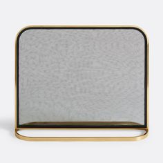 a gold and black metal fireplace screen on a white background with the top half open