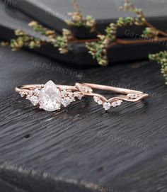 a rose cut diamond ring on top of a wooden table with greenery in the background