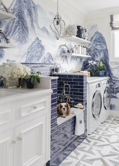 a laundry room with blue and white wallpaper, a washer and dryer