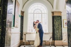 a bride and groom kissing in an old building