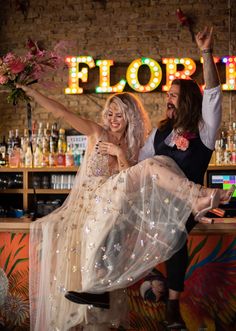 a man and woman dancing in front of a sign that says, how to rock a colorful urban wedding