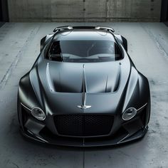 the front view of a black sports car in a parking garage with concrete flooring