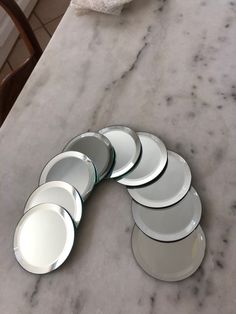 six plates are arranged on a marble countertop in the shape of a circle, and one is empty