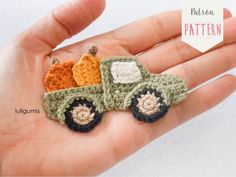 small crocheted toy truck with pumpkins on the front and back sitting in someone's hand