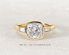 a yellow gold engagement ring with two baguettes on each side and an oval diamond center