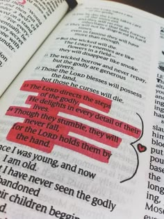 an open bible with red text on it