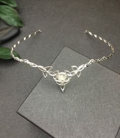 I've fabricated a Celtic inspired wedding bridal circlet, entirely in sterling silver, featuring 5 Trinity Knots with an 8mm round White Moonstone. If you wish a different gemstone, then please select from the gemstone list within the listing! This piece is lovely, hand-fabricated by me only and the circlet can be used for a wedding accessory, or any costuming event. Please allow me 5-7 business days to fabricate a new headpiece! **For matching earrings: https://www.etsy.com/listing/42139307/ste Delicate Hand Forged Jewelry For Wedding, Ceremonial Silver Bridal Necklace, Silver Round Bridal Necklace For Ceremonial Occasions, Hand Forged White Jewelry For Wedding, Delicate Silver Halo Jewelry, Adjustable Silver Round Bridal Necklace, Silver Adjustable Bridal Necklace, Silver Teardrop Crown Jewelry For Anniversary, Silver Hand Forged Jewelry For Wedding