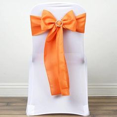 an orange bow tied to the back of a white chair