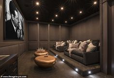 a home theater with two couches and a coffee table in front of the screen