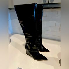 From The Asya Collection. Schutz’s Patent Leather Boots Feature A Pointed Toe And Side-Zip Closure. The Pair Is Elevated By A 109mm Wedge Heel. * 100% Patent Leather Upper * Pointed Toe * Side-Zip Closure * Synthetic Lining * 100% Leather Sole * Imported * True To Size * Wedge, 4.3” (109 Mm) * Shaft Height, 15.17” * Leg Opening, About 14.17” Trendy Fitted Wedge Boots For Party, Trendy Fitted Black Wedge Boots, Party Wedge Boots With Reinforced Heel, Black Knee-high Wedge Boots For Formal Occasions, Knee-high Wedge Boots For Formal Occasion, Trendy Leather Wedge Boots With Pointed Toe, Chic Round Toe Wedge Boots For Party, Chic Fitted Wedge Boots With Round Toe, Fitted Pointed Toe Wedge Boots For Party