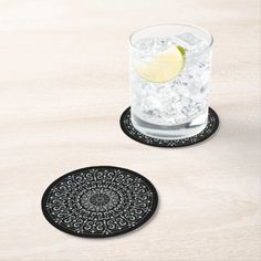 two black and white coasters with a lemon slice on the top one is for someone to drink