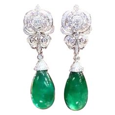 A pair of exquisite earrings boast a classic design that exude timeless elegance. The Emeralds , with their verdant green hue , captivate the eye with their vibrant brilliance . Nestled amongst the emeralds are glistering diamonds , which add a touch of glamour and luxury to the piece. Every detail is carefully crafted to perfection , making these earrings a true treasure to behold. Magnificent earrings come in 18k gold with 2 pieces of adorable Natural Zambian Emeralds, in perfect cabochon cut, spectacular vivid color, fine quality, only Minor treatment, of 50,00 carats, and 264 pieces of Natural Diamonds, of 2,60 carats, F-G color VS clarity. Handcrafted by artisan goldsmith. Complete with AIG report. Wholesale Price. Extremely HIGH QUALITY Product. Earring Video, Verdant Green, 18k Gold Earrings, Contemporary Chandelier, Zambian Emerald, Emerald Stone, Vivid Color, Modern Earrings, Modern Jewelry