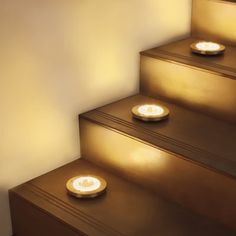 three lit candles sitting on top of some steps