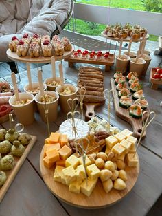 a wooden table topped with lots of different types of foods and desserts next to each other