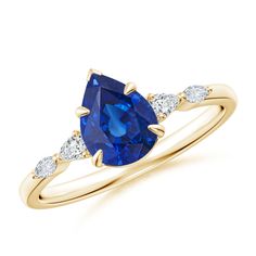 a yellow gold ring with an oval blue sapphire and three diamonds on the band, set in