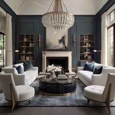 a living room filled with furniture and a chandelier hanging from the ceiling over a fire place