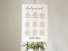 a seating chart on a wooden stand with flowers