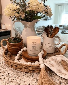 a tray with flowers and candles on top of a counter next to a kitchen sink