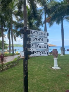 the sign is pointing in different directions to restaurants and shows where they are located on the beach