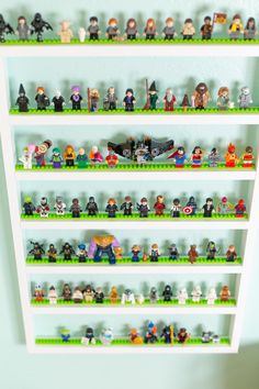 a shelf filled with lots of legos on top of green shelves next to a wall