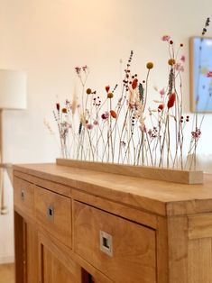 a wooden table topped with lots of different types of flowers on top of each other