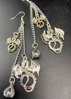 Unique and unusual dragon charm earrings. Adorned with gothic dragon charms and a glass pearl in a dragons talons. There are lightweight earrings which are nickel free and silver plated. They are about 4 inches long. These make a great gift idea! Long Dragon, Gothic Dragon, Earrings Gothic, Dragon Earrings, Gothic Earrings, Lightweight Earrings, Hanging Earrings, Earrings Long, Light Weight Earrings