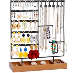 a jewelry rack with earrings and necklaces hanging from it's sides on a wooden stand