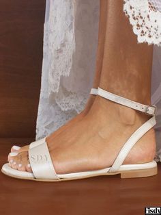 a woman's feet wearing white sandals