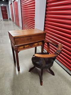 a desk and chair in front of a red storage unit at the self storage facility