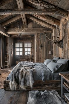 a rustic bedroom with wooden walls and ceiling beams, wood flooring, and bedding