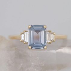 an aquamarinee and diamond ring with three baguettes on it's sides