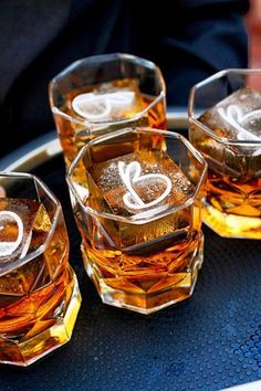 three glasses filled with ice sitting on top of a metal tray