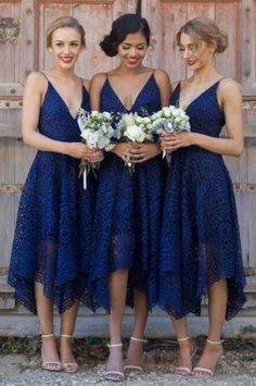 three women in dresses standing next to each other with flowers on their laps and holding bouquets