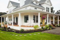 a large white house sitting on top of a lush green field