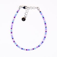 Playfully adorn your wrist with our Dainty bracelet, featuring a blend of purple, blue, and white seed beads. Bring a touch of charm to any outfit with this whimsical accessory. Materials:size 11/0 glass seed beadsbeading wiresilver plated crimp beadssilver plated wire guardssilver plated lobster claw claspsilver plated extension chainsilver plated logo charm Purple Beaded Chain Bracelets With Round Beads, Purple Beaded Chain Bracelet With Round Beads, Blue Beaded Chain Bracelets For Beach, Czech Glass Bracelets With Tiny Beads As A Gift, Bohemian Purple Beaded Bracelets With Letter Beads, Adjustable Purple Bracelet With Tiny Beads, Purple Beaded Bracelets With Tiny Beads For Beach, Adjustable Purple Bracelets With Tiny Beads, Purple Beaded Bracelets For Beach With Tiny Beads