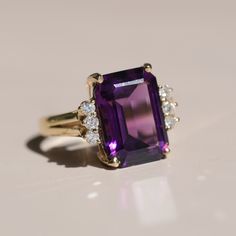 Materials: 14k Yellow Gold, Diamond, and Amethyst 14.3 x 15.6mm Size: 5 3/4 Luxury Oval Amethyst Ring, Elegant Style, Luxury Oval Amethyst Ring For Weddings, Luxury Classic Amethyst Ring, Luxury Classic Amethyst Ring With Gemstone Accents, Luxury Amethyst Ring With Intricate Design, Luxury Vintage Amethyst Ring For Formal Occasions, Luxury Marquise Cut Amethyst Ring For Anniversary, Luxury Multi-stone Yellow Gold Amethyst Ring, Formal 14k Gold Amethyst Ring