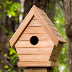 a wooden birdhouse with a hole in the roof