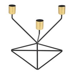 three candles are placed in the shape of an inverted triangle, with gold and black accents