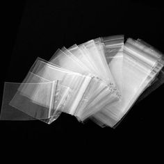 several clear bags are stacked on top of each other in this black and white photo