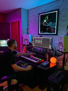 a man sitting at a desk in front of a computer and sound mixing equipment on it