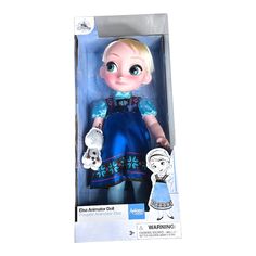 the doll is in its box and it has blue dress with white gloves on top