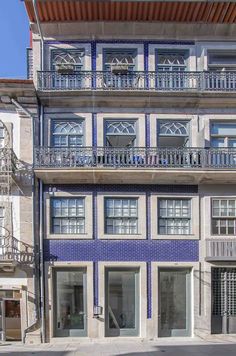 an apartment building with balconies on the second floor is painted blue and white