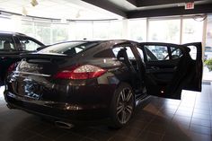 two cars parked in a showroom with open doors