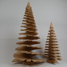 two wooden christmas trees on a white surface